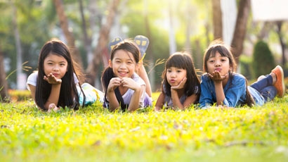 陽光下躺在綠草地上的亞洲小女孩