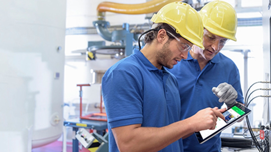 Two technicians monitoring electrical systems performance