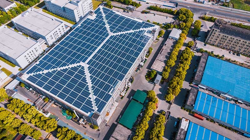 An aerial view of a solar panel factory, producing clean energy for electric utilities and smart grid system.
