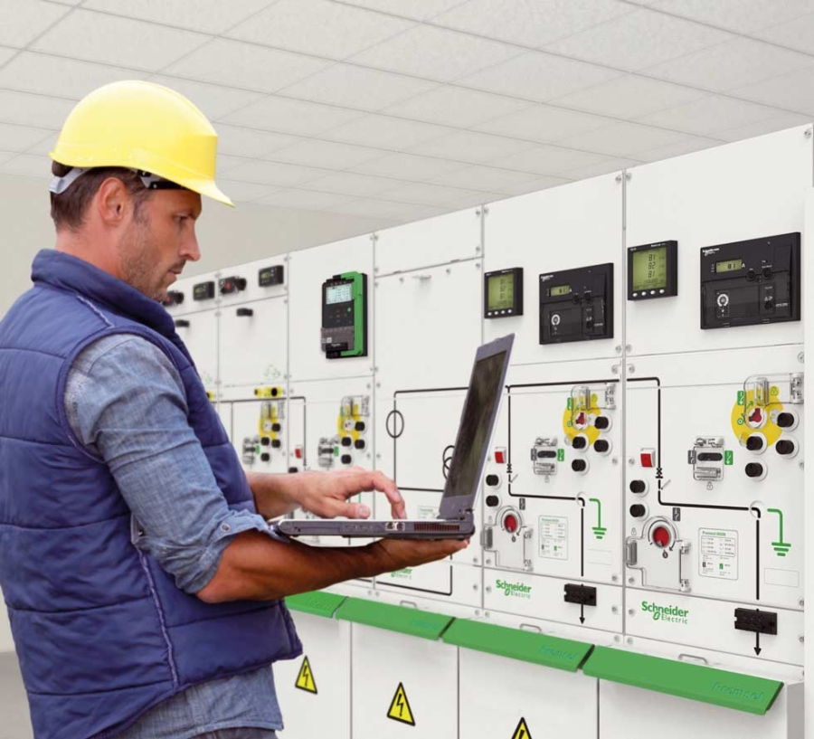 工程師在樓宇自動化控制面板前使用筆記本電腦